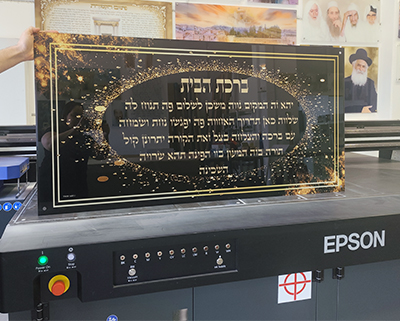ברכת הבית מודפסת על זכוכית מחוסמת בגווני שחור וזהב בעיצוב פנורמי..