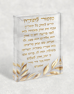 בלוק זכוכית אקרילי עם ברכת מזמור לתודה בגווני זהב על רקע שיש בהיר