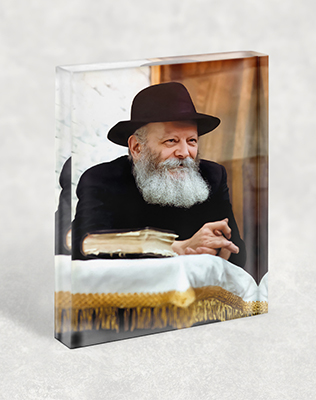 הרבי מלובביץ' נשען על הסטנדר ומחייך על בלוק זכוכית אקרילי